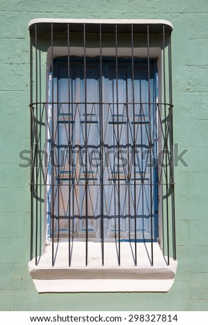 Detail of wooden window with bars in classical colonial architecture in the old city of Ciudad Bolivar, Venezuela