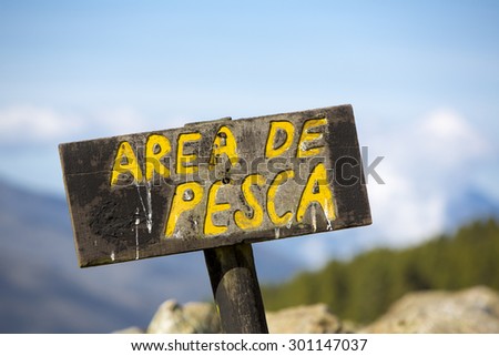 Spanish wooden sign post showing the free fishing area near the river in the mountains of Merida.