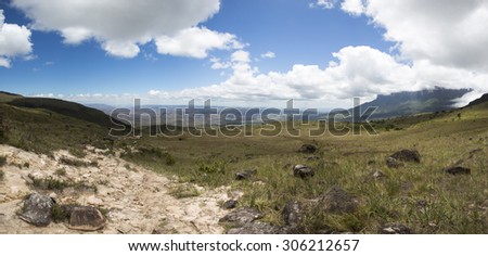 Panorama of landscape from Gran Sabana. White clouds in blue sky over table-top mountains called Tepui. Mount Roraima, Venezuela.