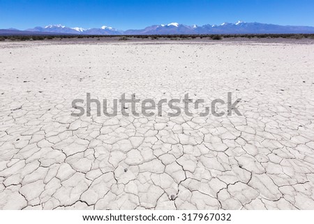 Drought land on the Pampa of El Leoncito with the Andean mountains against a clear blue sky. San Juan Province, Argentina