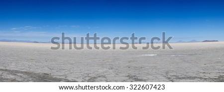 View of the Salar of Uyuni against a blue sky during the dry season, the salt plains are a completely flat expanse of dry salt. Bolivia