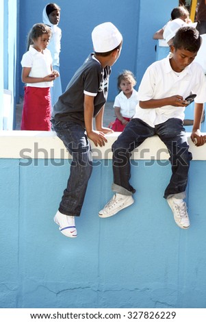CAPE TOWN, SOUTH AFRICA, NOVEMBER 26: Teenagers boy playing with their mobile phone around in Bo-Kaap, Malay Quarter, Cape Town. South Africa 2006
