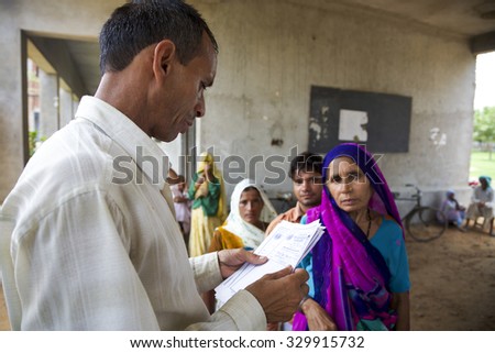 AGRA, INDIA, JULY 18: Indian doctor consulting a patient medical note. Medical free treatment provided by Pushpanjali Fair Trade Organization project. India 2013. (Selective focus)