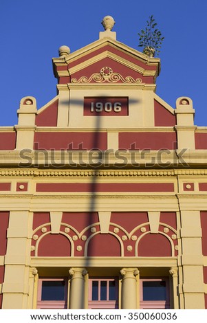 Details of the old colonial market facade build in 1906 in Manaus with sunset light ad clear blue sky. Amazonas State, Brazil