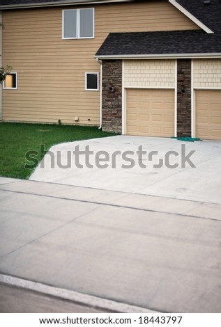 Empty Suburban driveway with blank facade and indication of two car garage in a typical suburban subdivision