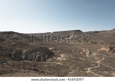 American western high desert plains landscape with dry winding dusty trail in the valley - Central Oregon