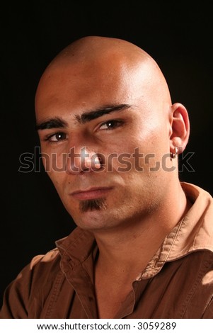 Portrait of a serious young shaved head eyes open