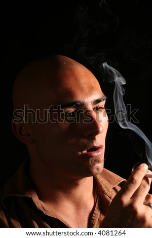 young man with shaved head smoking cigarette