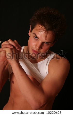 Sexy well build young man black background with vest