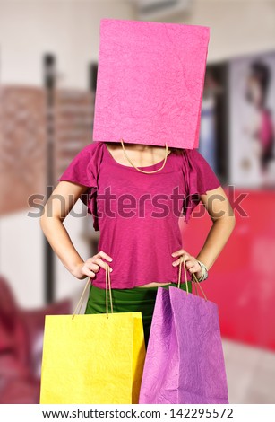 Girl with package on her head and two in the hands at shop