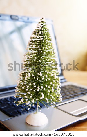 Toy pine tree at laptop