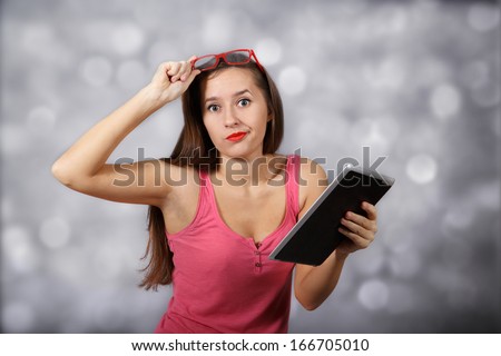 Amazed girl with tablet pc at light background