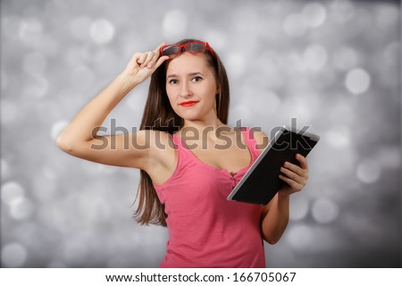 Girl at glasses with tablet pc at light background