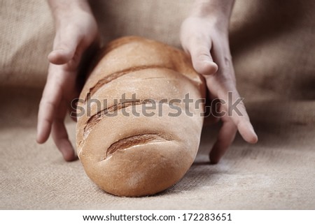 long loaf of bread with male hands
