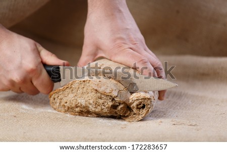 Male hands cut bread with knife