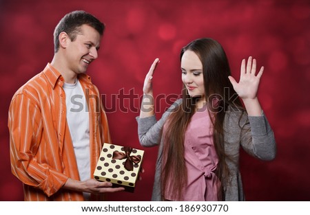 Boy gives present to girl at light background