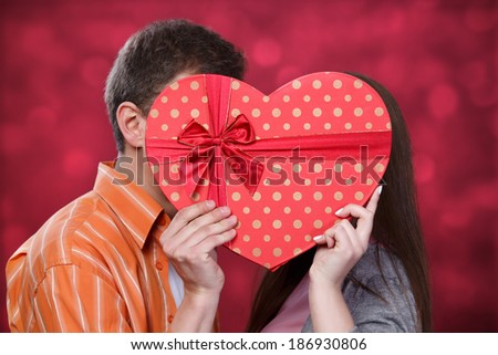 Man and woman kissing in a heart-shaped box
