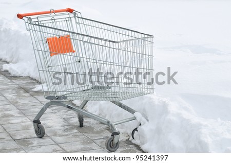Metal shopping carts at supermarket parking covered with snow