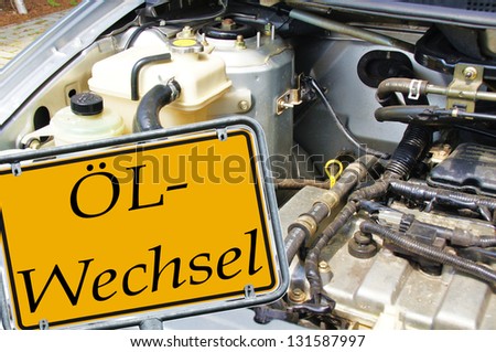 Engine compartment car with a sign and the german words oil change / oil change