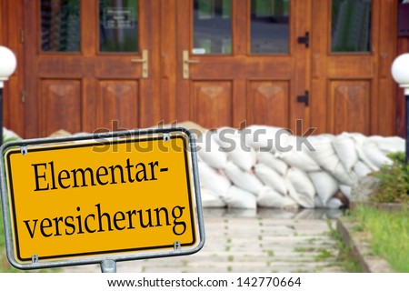 Sand bags and shield with the german words Elemental insurance / Elemental insurance