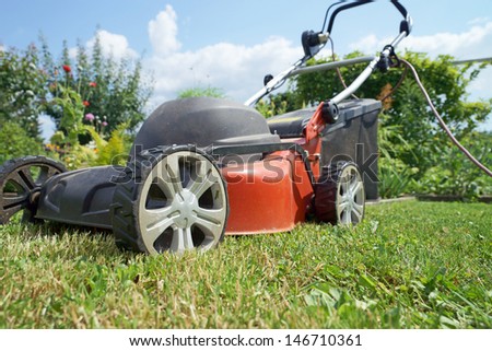 Lawn mower on a lawn in the garden / gardening