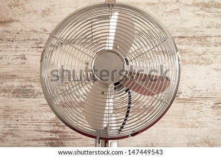 table fan over a wooden background / table fan