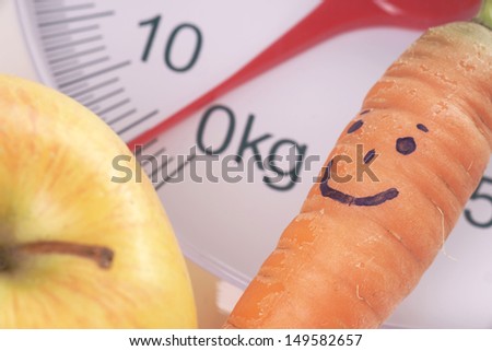 Carrot and apple on a bathroom scale / healthy living