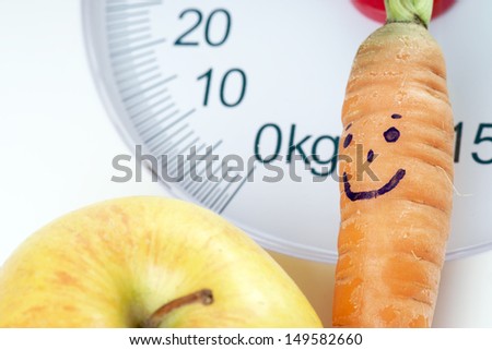 Carrot and apple on a bathroom scale / healthy living