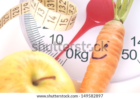 Carrot and apple on a bathroom scale / diet