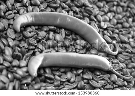 Chili peppers with coffee beans in black and white / coffee and chili