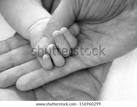 Hands holding a baby hand in black and white / Family