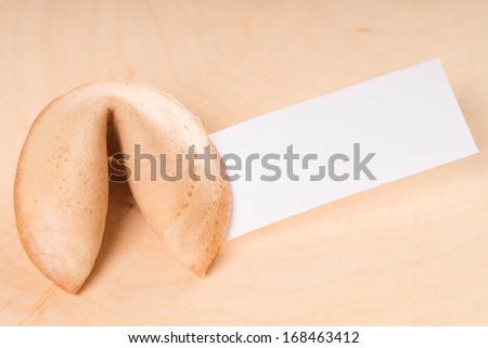 Fortune cookie with blank piece of paper on a wooden board / Fortune Cookie