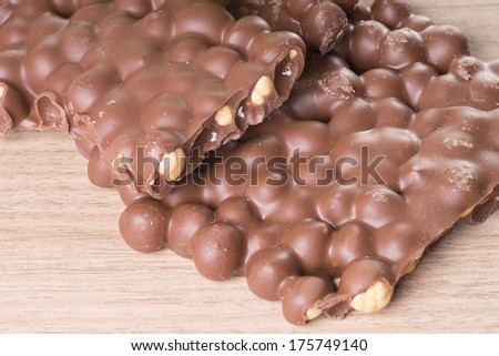 Chocolate with nuts on a wooden board / chocolate