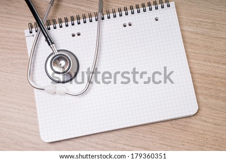 blank writing pad with stethoscope on a table / blank writing pad