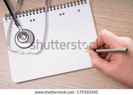 blank writing pad with stethoscope on a table / blank writing pad