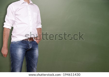 Man in shirt and jeans in front of an empty chalk board / modern man