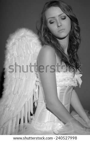 pretty woman in a angel costume in black and white / Angel