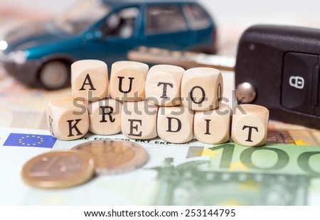 money and wood cubes with the german words car loan / car loan