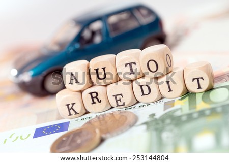 Money and wood cubes with the german words car loan / car loan