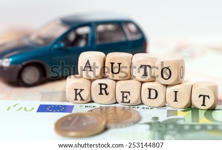 Money and wood cubes with the german words car loan / car loan