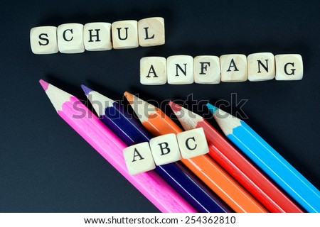 Chalkboard and wood dice with the german words school beginning and ABC / ABC