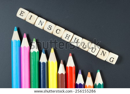 Colored pencils and wood dice with the german word school enrollment / school enrollment