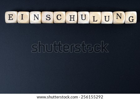 Chalkboard and wood dice with the german word school enrollment / school enrollment