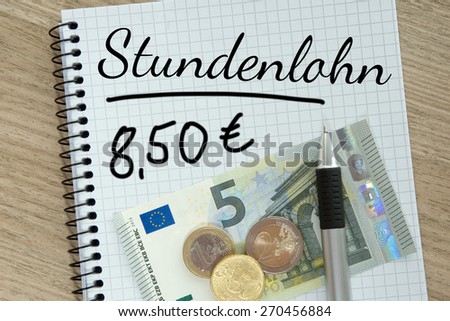 Writing pad with money and the german words hourly wage / hourly wage
