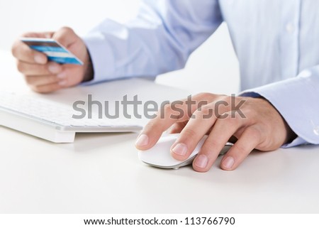 Male hand using computer and credit card for online payment