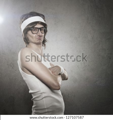 Retro sport nerd with serious face expression acting like a tough guy over gray background with copy space
