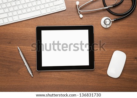 Close up of blank digital tablet at doctor\'s desk with clipping path for the screen