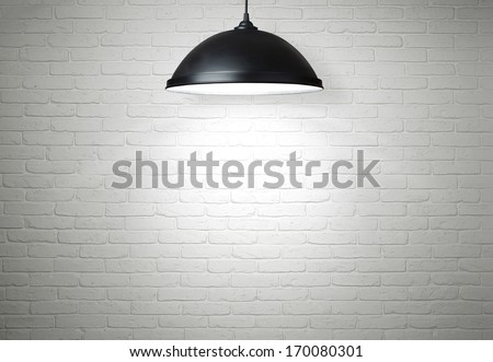 White brick wall illuminated by the ceiling lamp with copy space