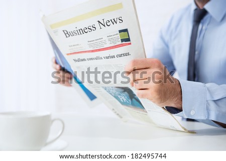 Close up of young businessman reading business news