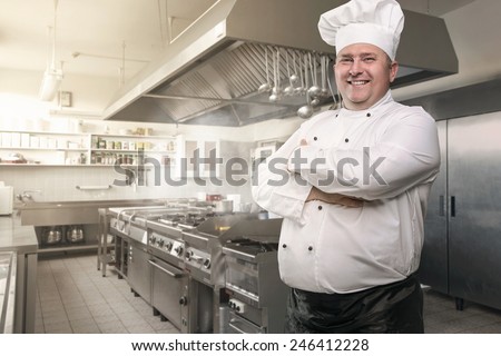 Portrait of a happy chef in the industrial kitchen with copy space
